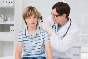 doctor checking child patient's ear