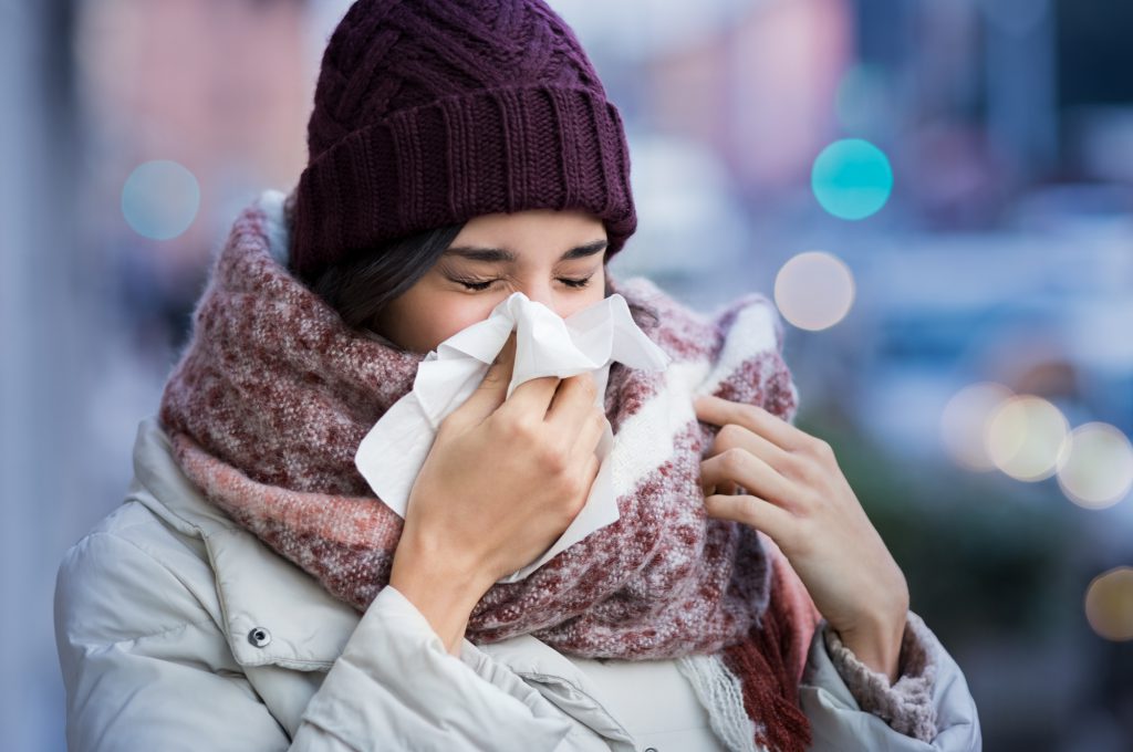 woman sneezing otuside