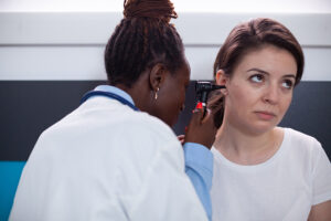 A doctor examines a woman’s ear